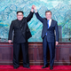 The leaders raise their hands at the truce village of Panmunjom inside the demilitarized zone.